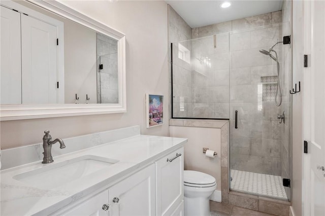 bathroom with toilet, vanity, recessed lighting, and a stall shower