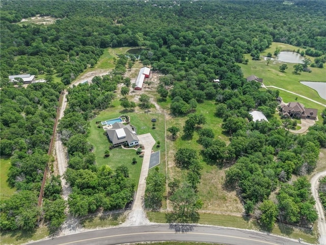 birds eye view of property featuring a wooded view and a water view