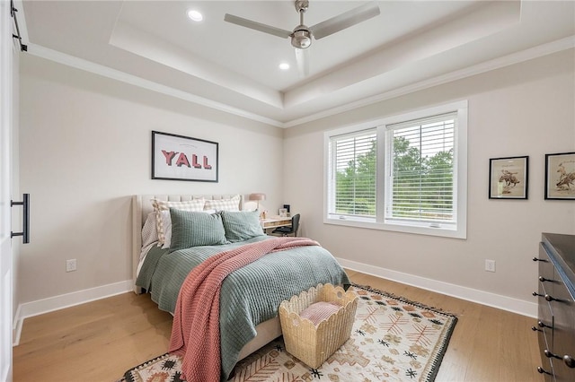 bedroom with recessed lighting, a raised ceiling, wood finished floors, crown molding, and baseboards