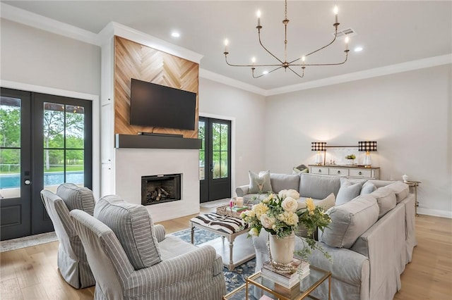 living room featuring ornamental molding, an inviting chandelier, a healthy amount of sunlight, and french doors