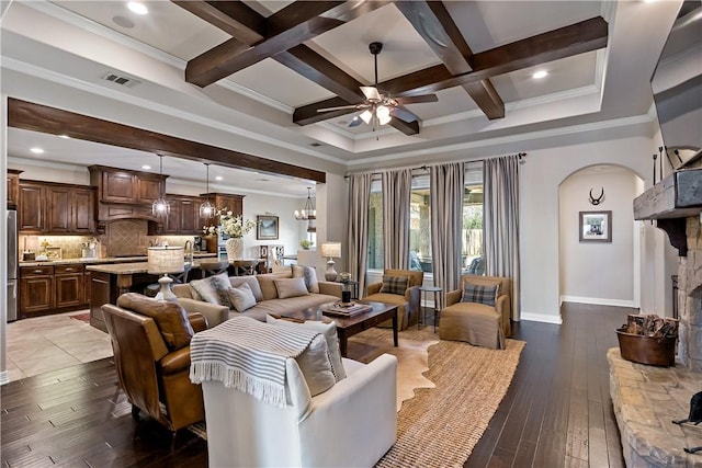 living room with visible vents, coffered ceiling, beamed ceiling, and a stone fireplace