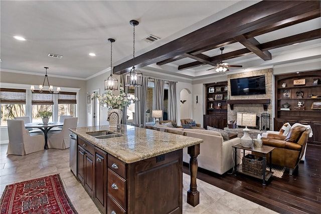 kitchen with a stone fireplace, coffered ceiling, visible vents, stainless steel dishwasher, and beam ceiling