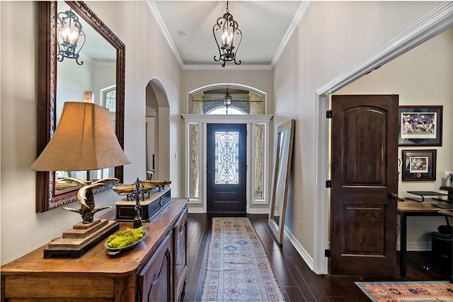 foyer with an inviting chandelier, baseboards, dark wood-style floors, and crown molding