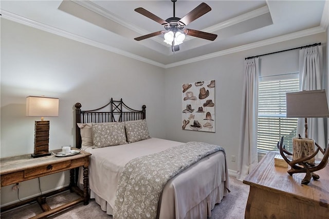 bedroom featuring light carpet, a ceiling fan, a tray ceiling, and crown molding