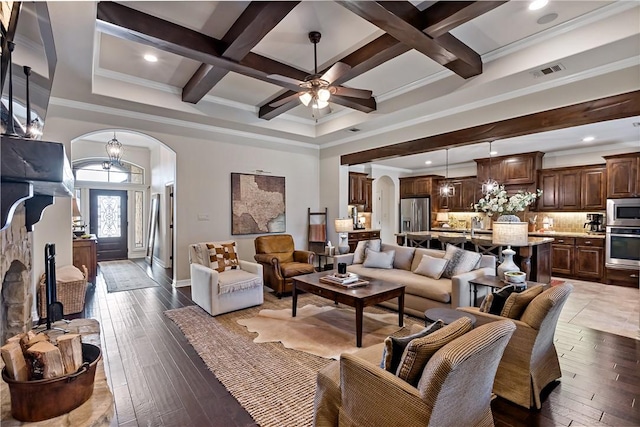 living room featuring arched walkways, visible vents, coffered ceiling, beamed ceiling, and hardwood / wood-style flooring