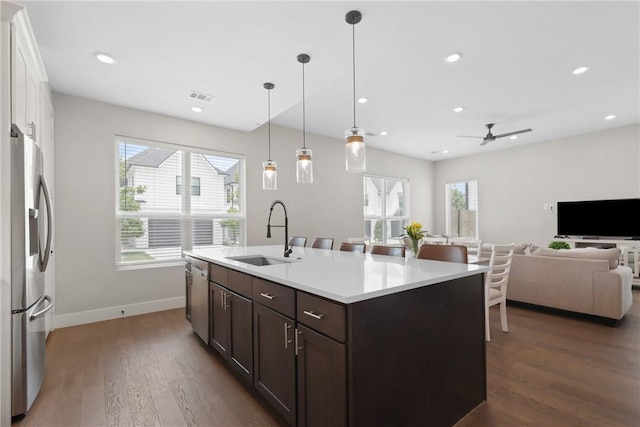 273 Estates Cir, College Station, TX 77840 - kitchen featuring appliances with stainless steel finishes, a sink, dark brown cabinets, a ceiling fan, and dark wood finished floors