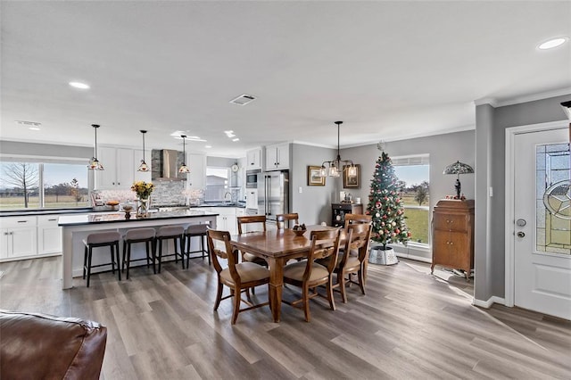 dining space featuring hardwood / wood-style floors, crown molding, and a chandelier