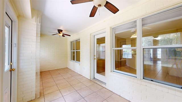 unfurnished sunroom featuring ceiling fan