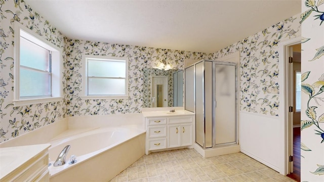 bathroom with vanity and shower with separate bathtub