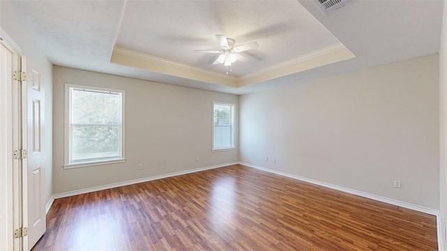 spare room with ceiling fan, ornamental molding, dark hardwood / wood-style floors, and a raised ceiling