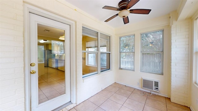 unfurnished sunroom with ceiling fan