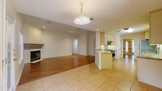 kitchen with light tile patterned flooring, appliances with stainless steel finishes, sink, and kitchen peninsula