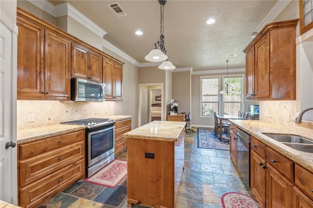 4413 Hearst Ct, College Station, TX 77845 - kitchen featuring stainless steel appliances, stone tile floors, ornamental molding, recessed lighting, and a center island