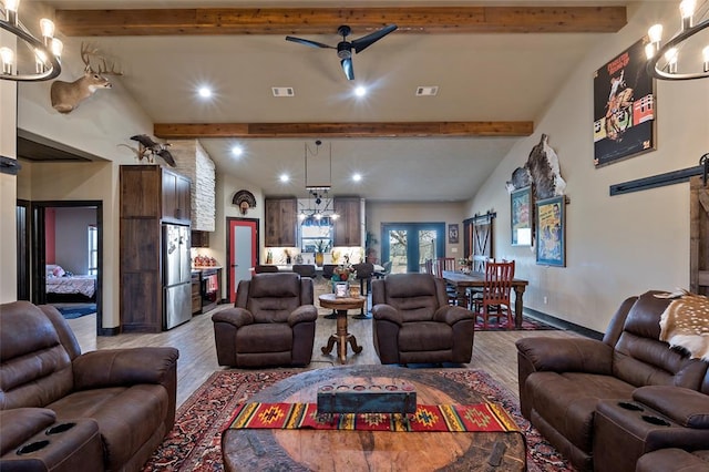 living room with a barn door, a notable chandelier, visible vents, and light wood finished floors