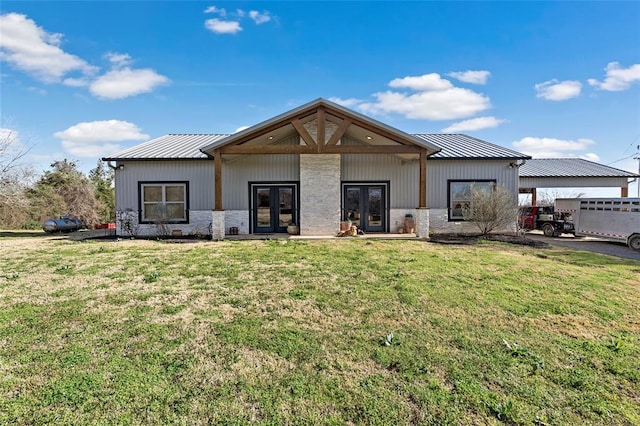 rear view of property with a yard, french doors, and metal roof