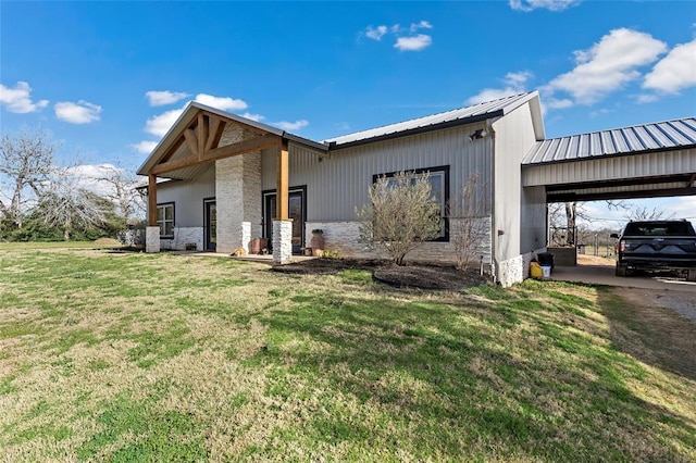 view of front of property featuring a carport, a front yard, and metal roof