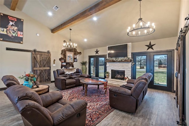 living room featuring a barn door, a notable chandelier, and french doors