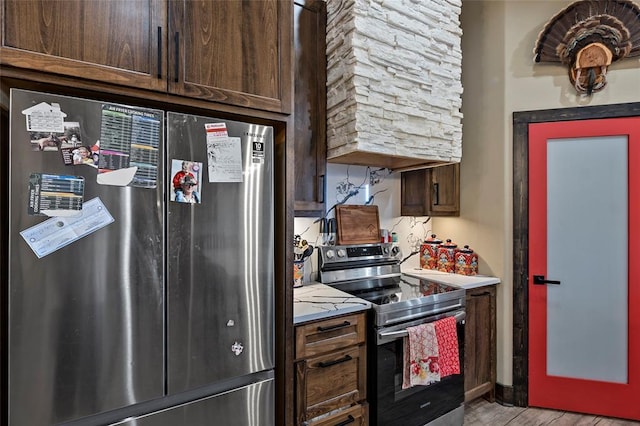 kitchen with dark brown cabinetry, light countertops, and stainless steel appliances