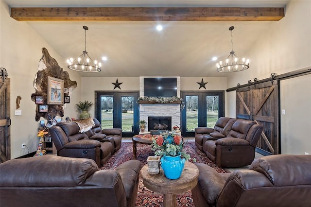 living area featuring beam ceiling, a fireplace, a barn door, and an inviting chandelier