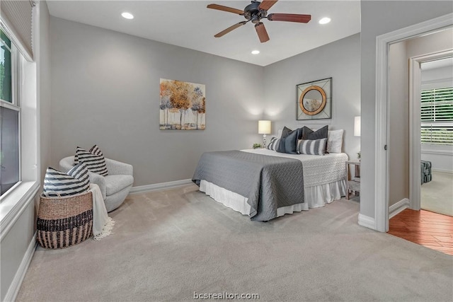 bedroom featuring light carpet, multiple windows, and ceiling fan