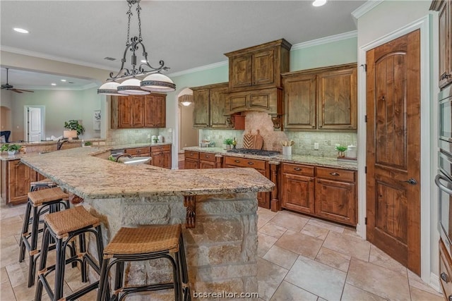 kitchen featuring ceiling fan, backsplash, kitchen peninsula, decorative light fixtures, and a kitchen bar