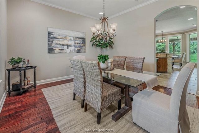 dining room featuring hardwood / wood-style flooring, crown molding, and a chandelier