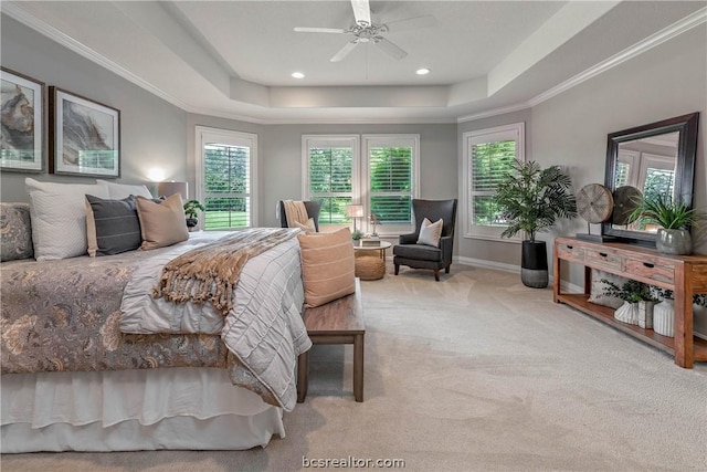 bedroom with ornamental molding, a tray ceiling, ceiling fan, and light colored carpet