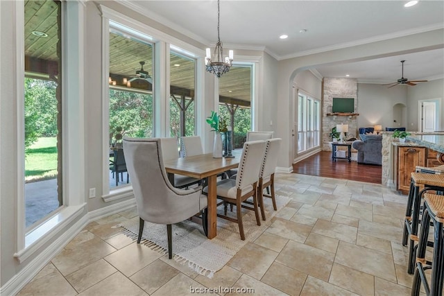 dining space featuring ceiling fan with notable chandelier and ornamental molding