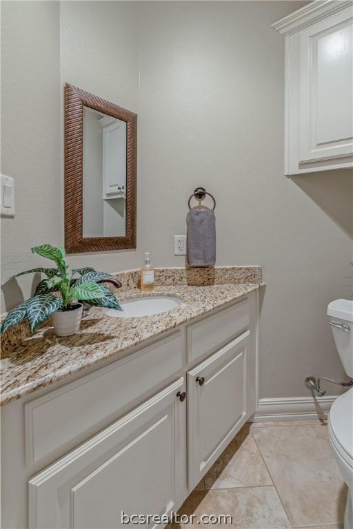 bathroom with tile patterned floors, vanity, and toilet