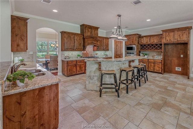 kitchen with sink, stainless steel appliances, kitchen peninsula, a breakfast bar area, and decorative backsplash