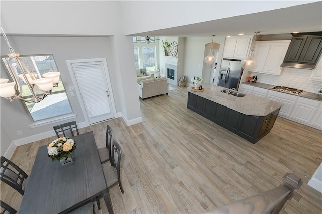 kitchen featuring white cabinetry, sink, stainless steel appliances, tasteful backsplash, and light hardwood / wood-style floors