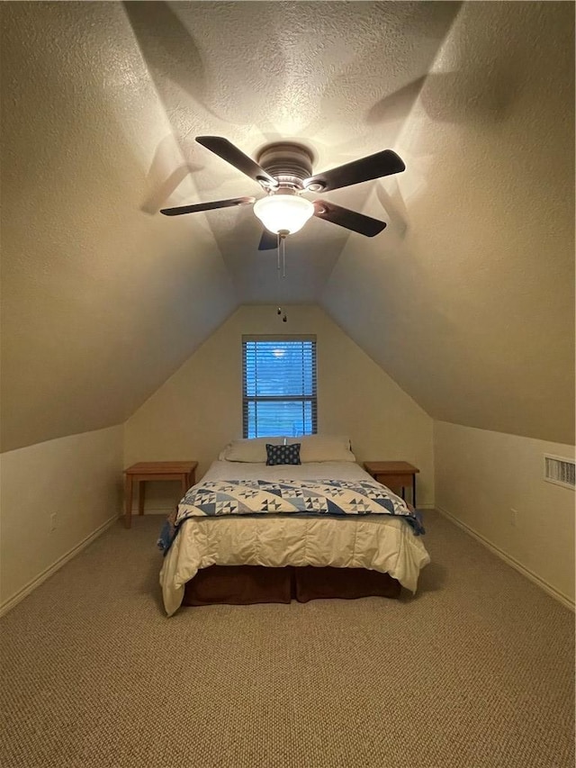 unfurnished bedroom with carpet, lofted ceiling, ceiling fan, and a textured ceiling