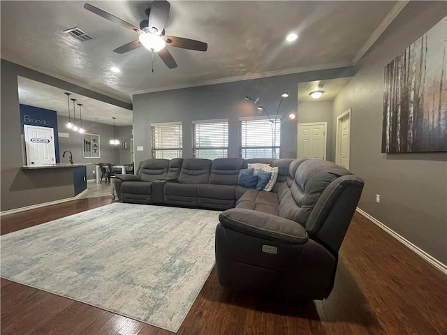 living room with sink, crown molding, dark wood-type flooring, and ceiling fan