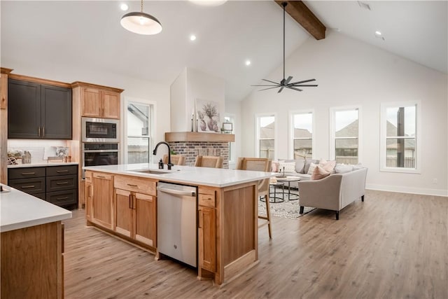 kitchen featuring pendant lighting, sink, an island with sink, and appliances with stainless steel finishes