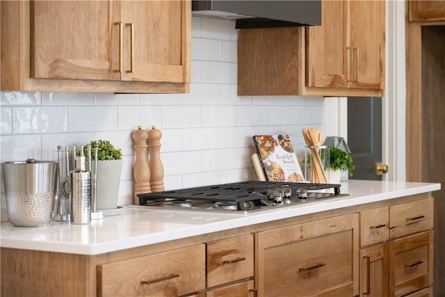 kitchen featuring tasteful backsplash, stainless steel gas cooktop, and wall chimney range hood