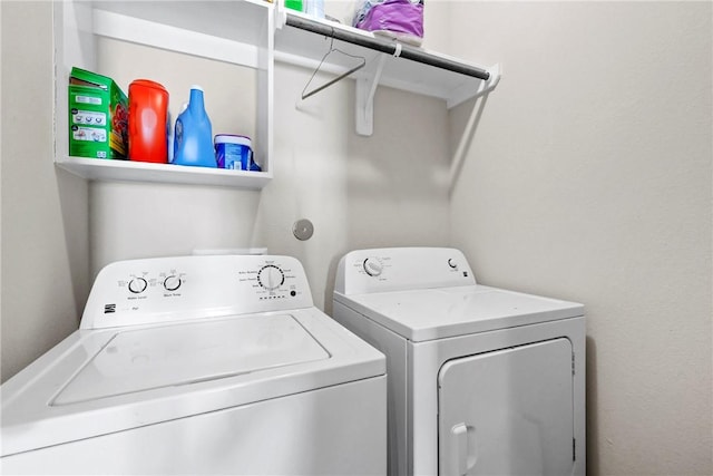 clothes washing area with washer and clothes dryer and laundry area