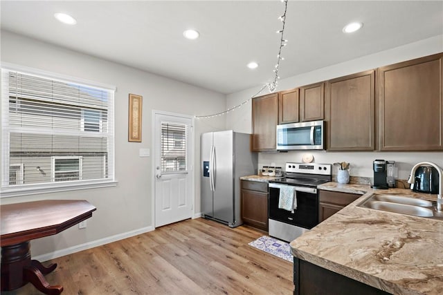 kitchen featuring light wood finished floors, recessed lighting, a sink, and stainless steel appliances
