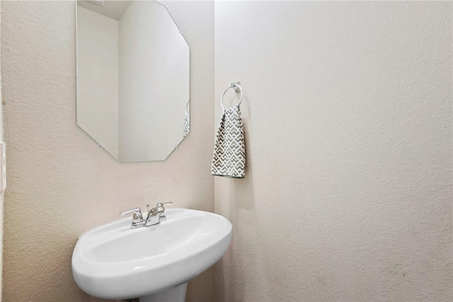 bathroom with a sink and a textured wall