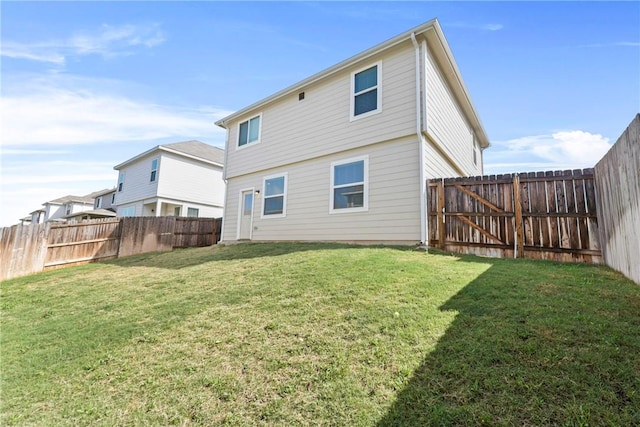 back of property featuring a fenced backyard and a lawn
