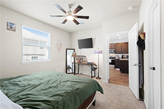 bedroom with light colored carpet, ceiling fan, visible vents, and baseboards