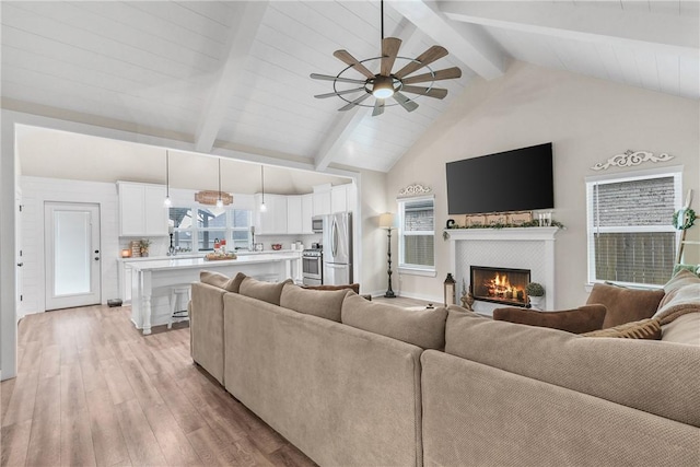 4019 Heru Ct, College Station, TX 77845 - living area with a tiled fireplace, light wood-type flooring, beam ceiling, ceiling fan, and high vaulted ceiling