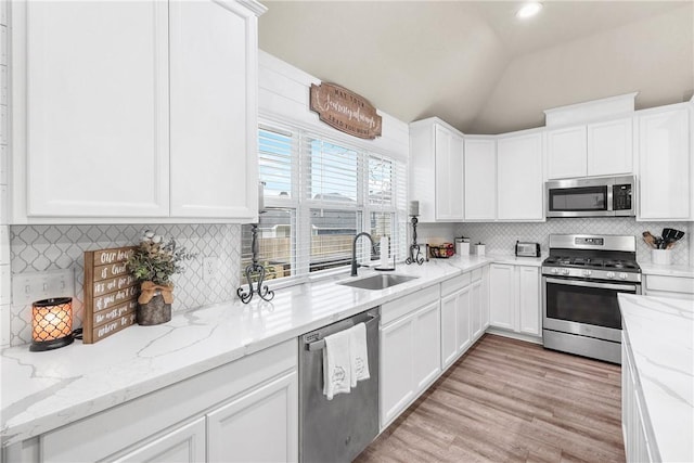 4019 Heru Ct, College Station, TX 77845 - kitchen featuring appliances with stainless steel finishes, white cabinets, and lofted ceiling