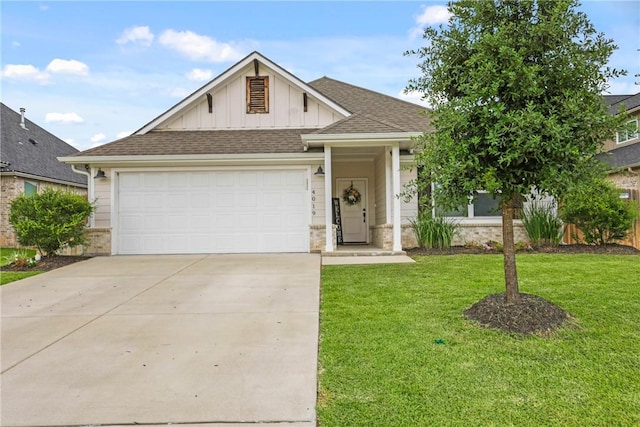 4019 Heru Ct, College Station, TX 77845 - view of front of home featuring board and batten siding, a front lawn, an attached garage, driveway, and a shingled roof