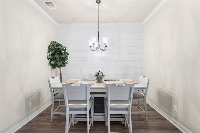 4019 Heru Ct, College Station, TX 77845 - dining area featuring crown molding, a chandelier, and dark wood-style floors