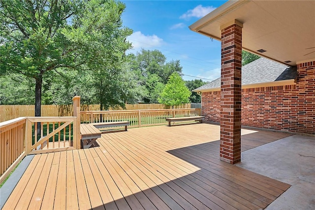 wooden terrace with a fenced backyard