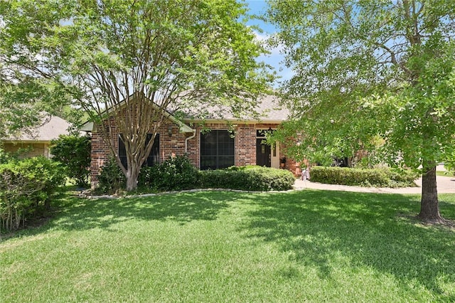 single story home with a front lawn and brick siding