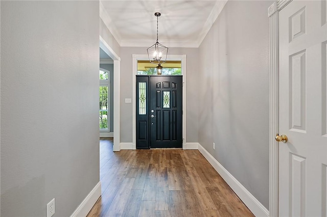 foyer featuring wood finished floors, baseboards, and crown molding