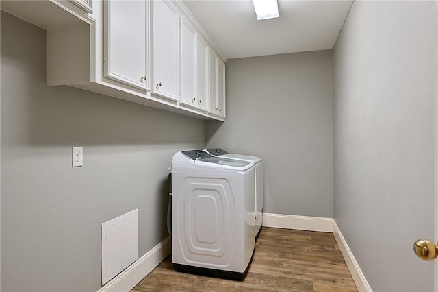 laundry room with washing machine and dryer, cabinet space, wood finished floors, and baseboards