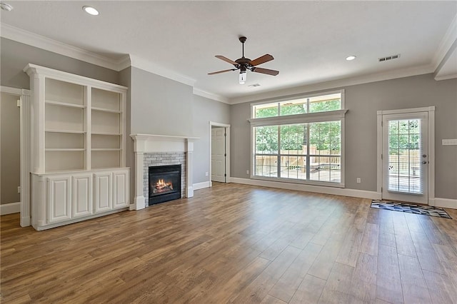 unfurnished living room featuring a ceiling fan, a brick fireplace, wood finished floors, baseboards, and recessed lighting