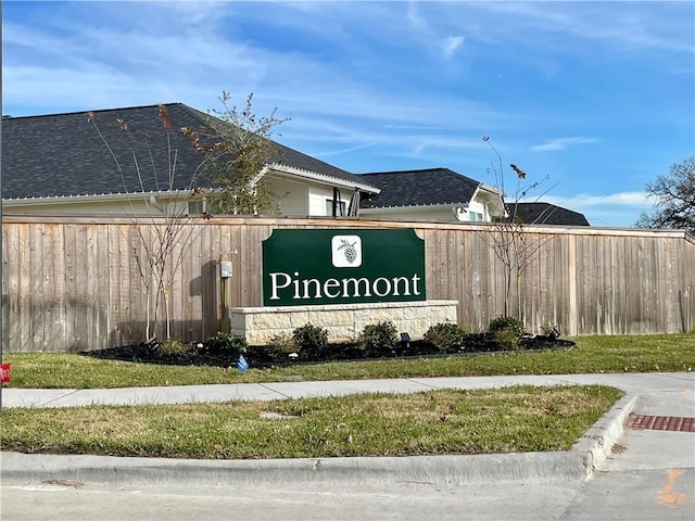 community / neighborhood sign featuring fence